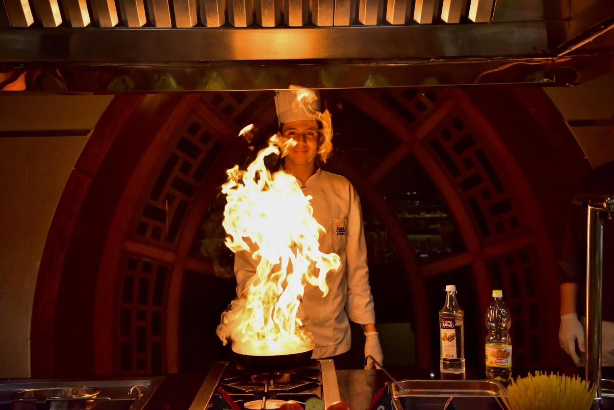 The Grand Hotel Sharm El Sheikh Eksteriør bilde A chef cooking with a flaming wok